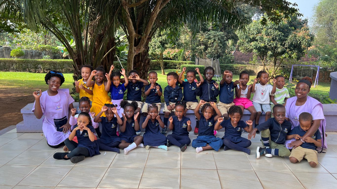 Acres of Fun students and teachers posing together outdoors under a tree